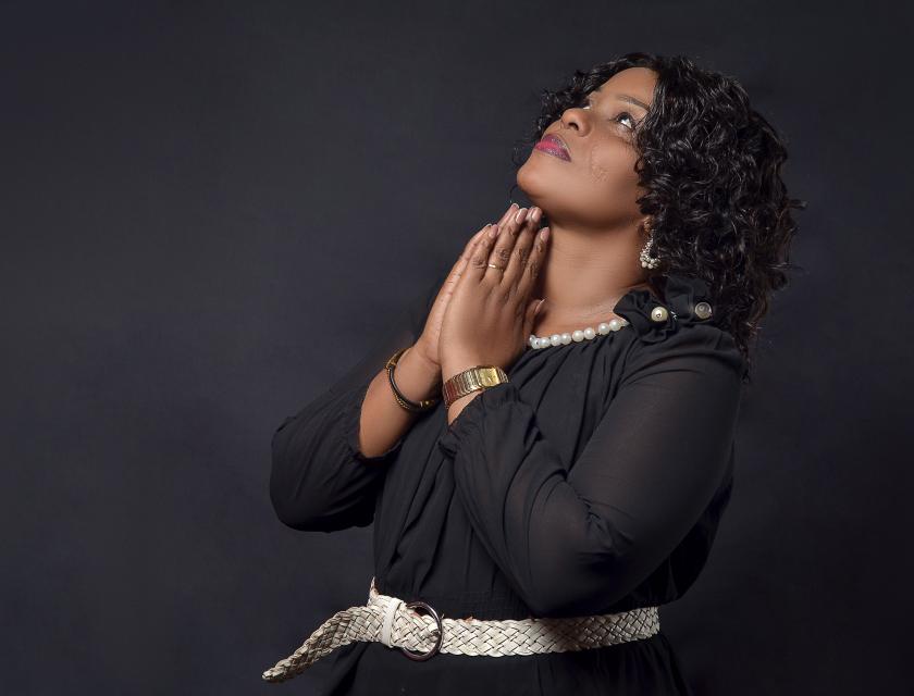 Rosine Mack, les deux mains jointes, regarde vers le ciel