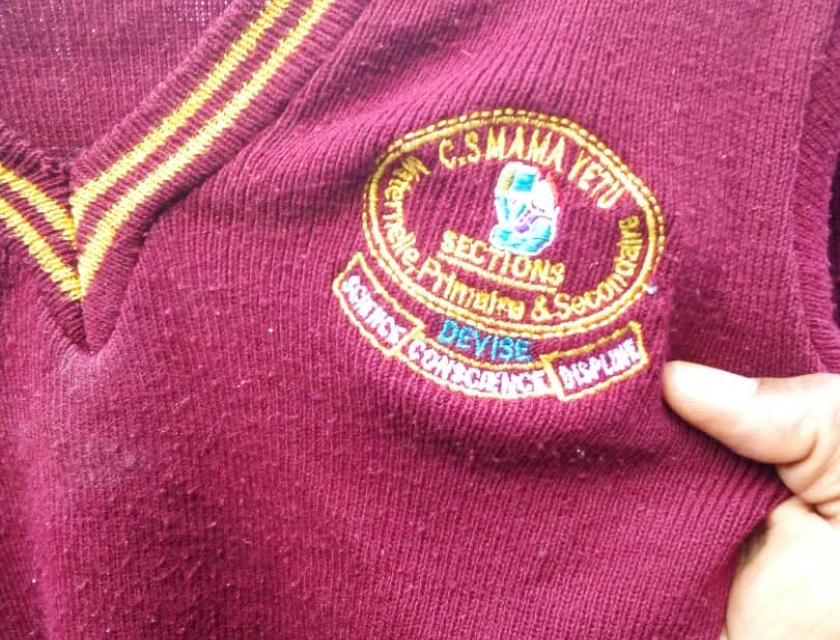 Un tricot portant le logo de l'école primaire Mama yetu porté par les victimes