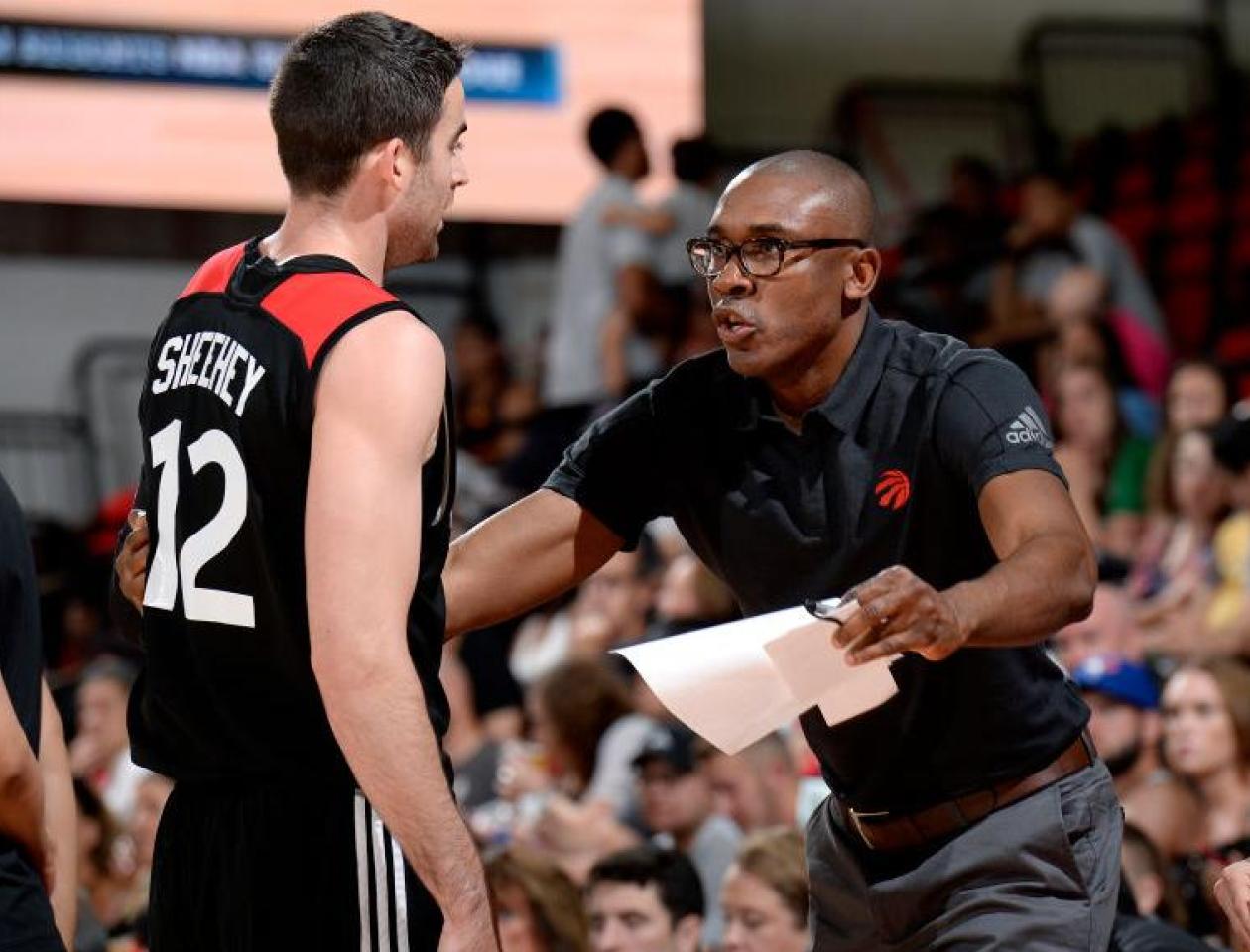 Patrick Mutombo discute avec un joueur des Raptors