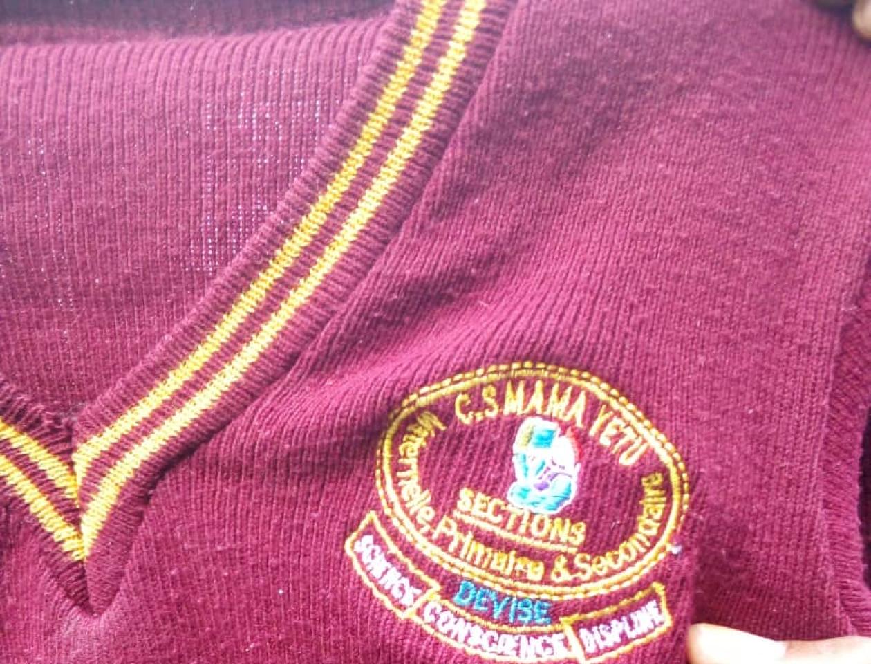Un tricot portant le logo de l'école primaire Mama yetu porté par les victimes